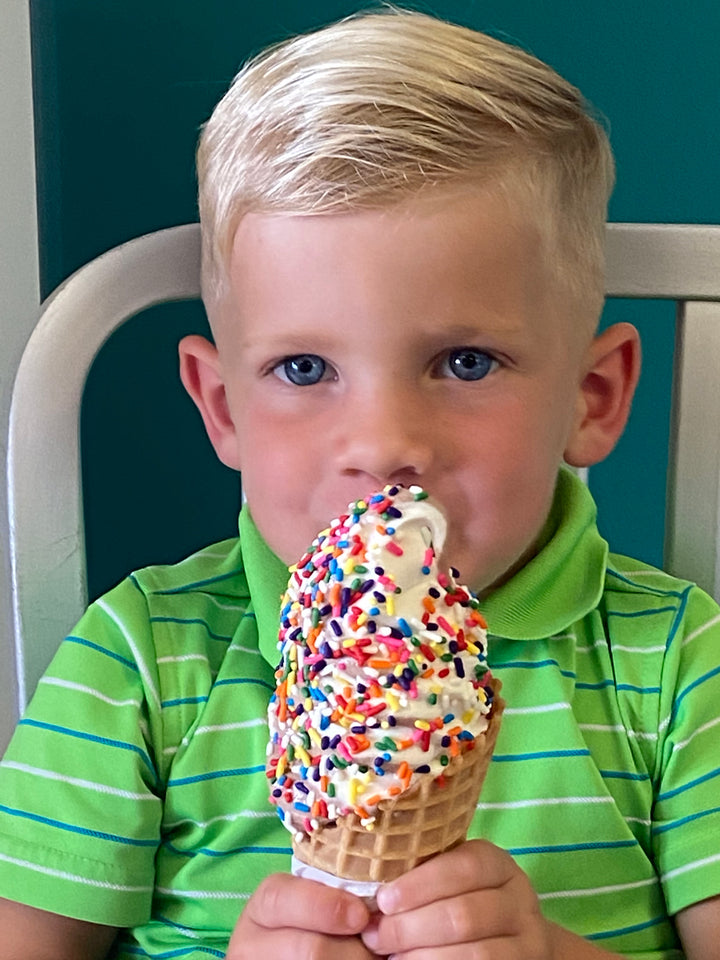 Boy eating ice cream with sprinkles..